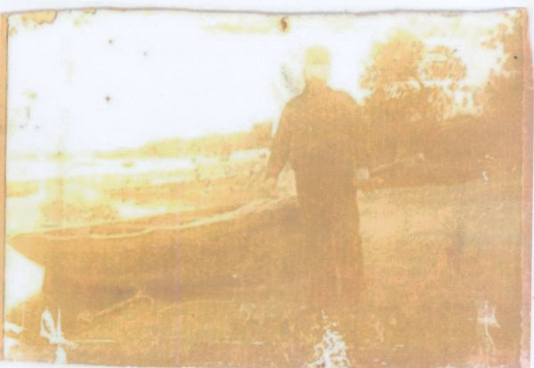 Copy of a photograph of a man possibly Georgie Palmer stood by a boat unnamed and undated. Llangwm Pembrokeshire